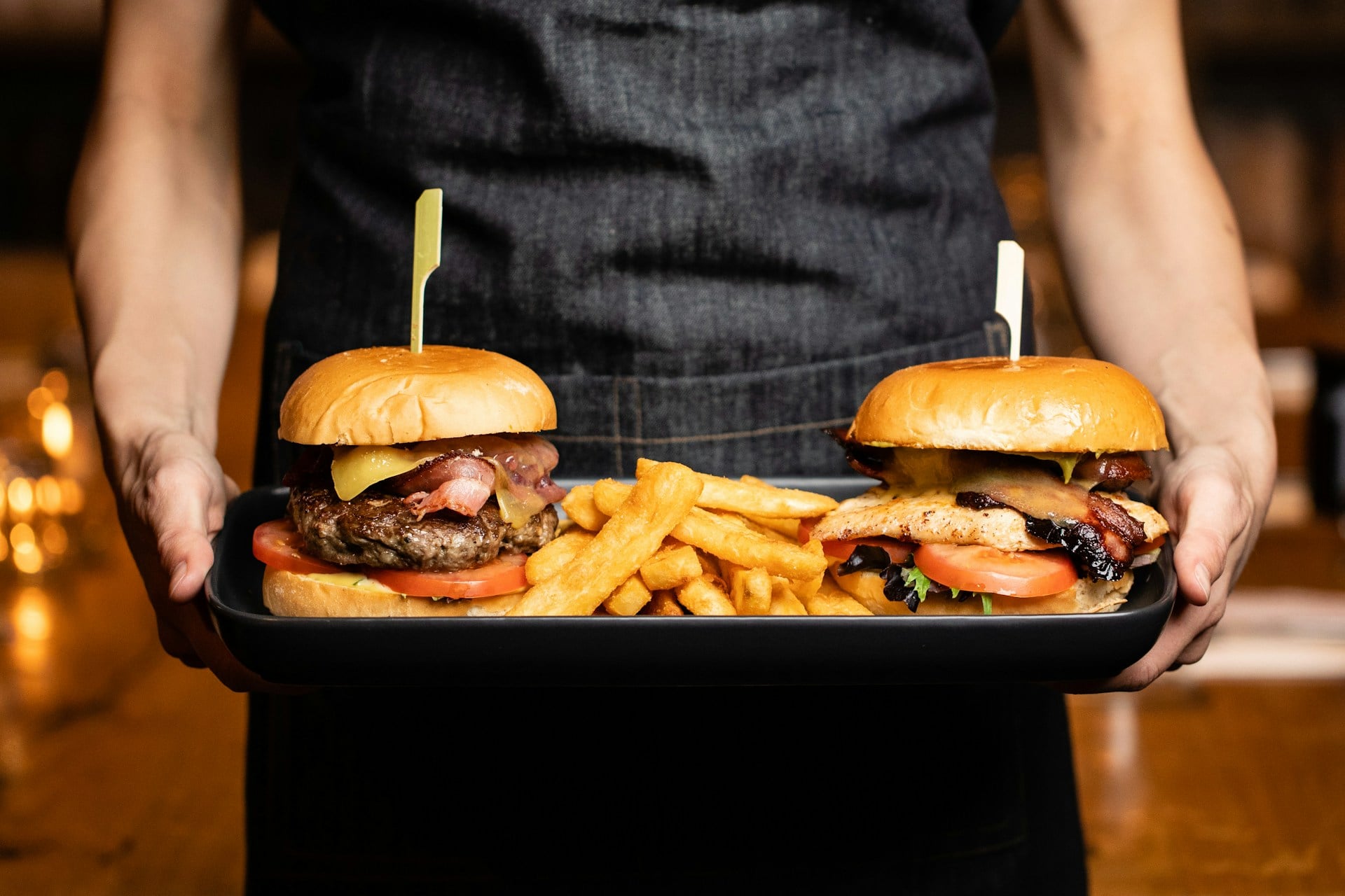 person serving plant based burger with fries